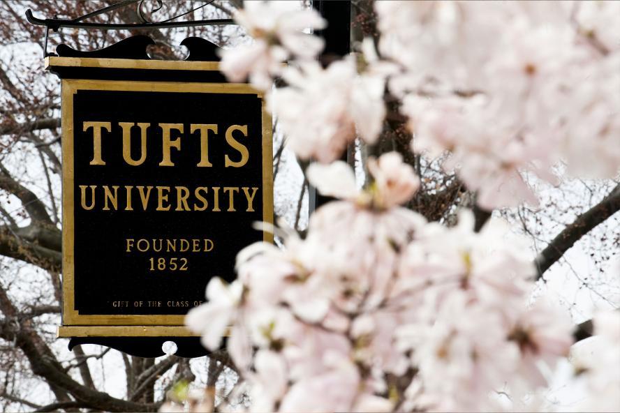 Tufts University sign amid spring blossoms